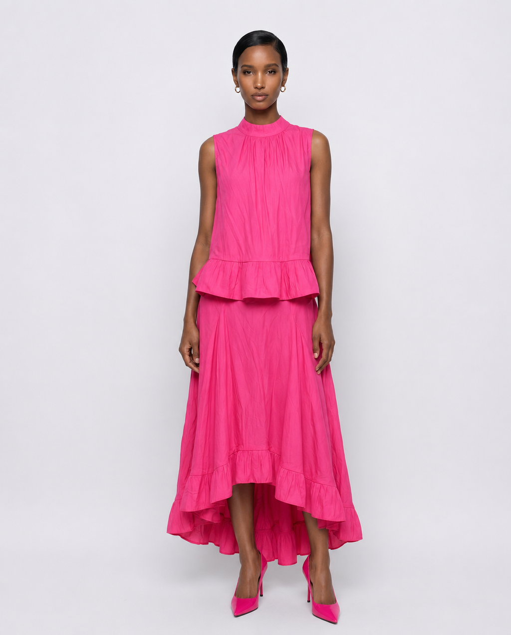 A bright pink sleeveless peplum top with a matching flowy skirt.