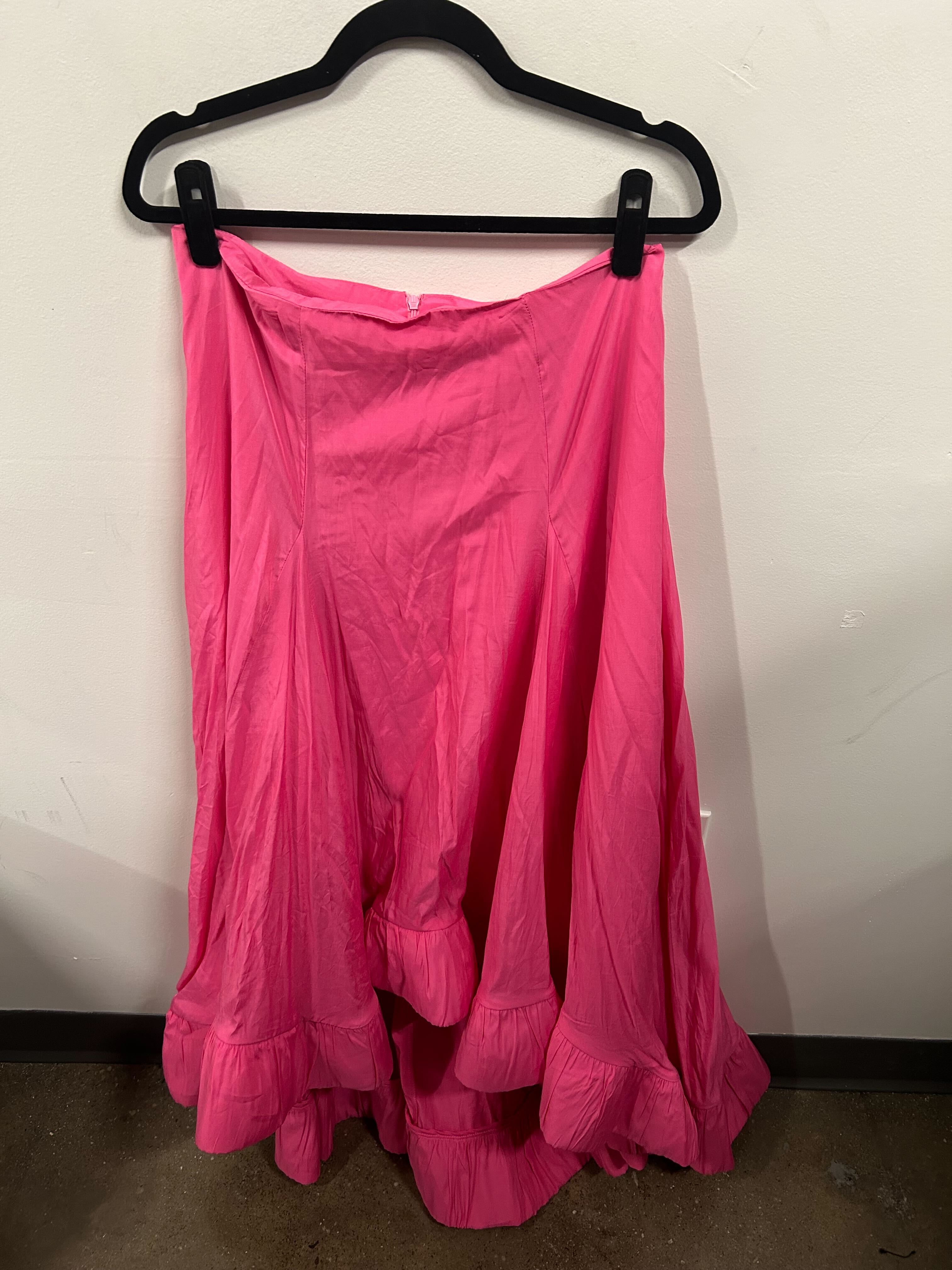 A bright pink sleeveless peplum top with a matching flowy skirt.