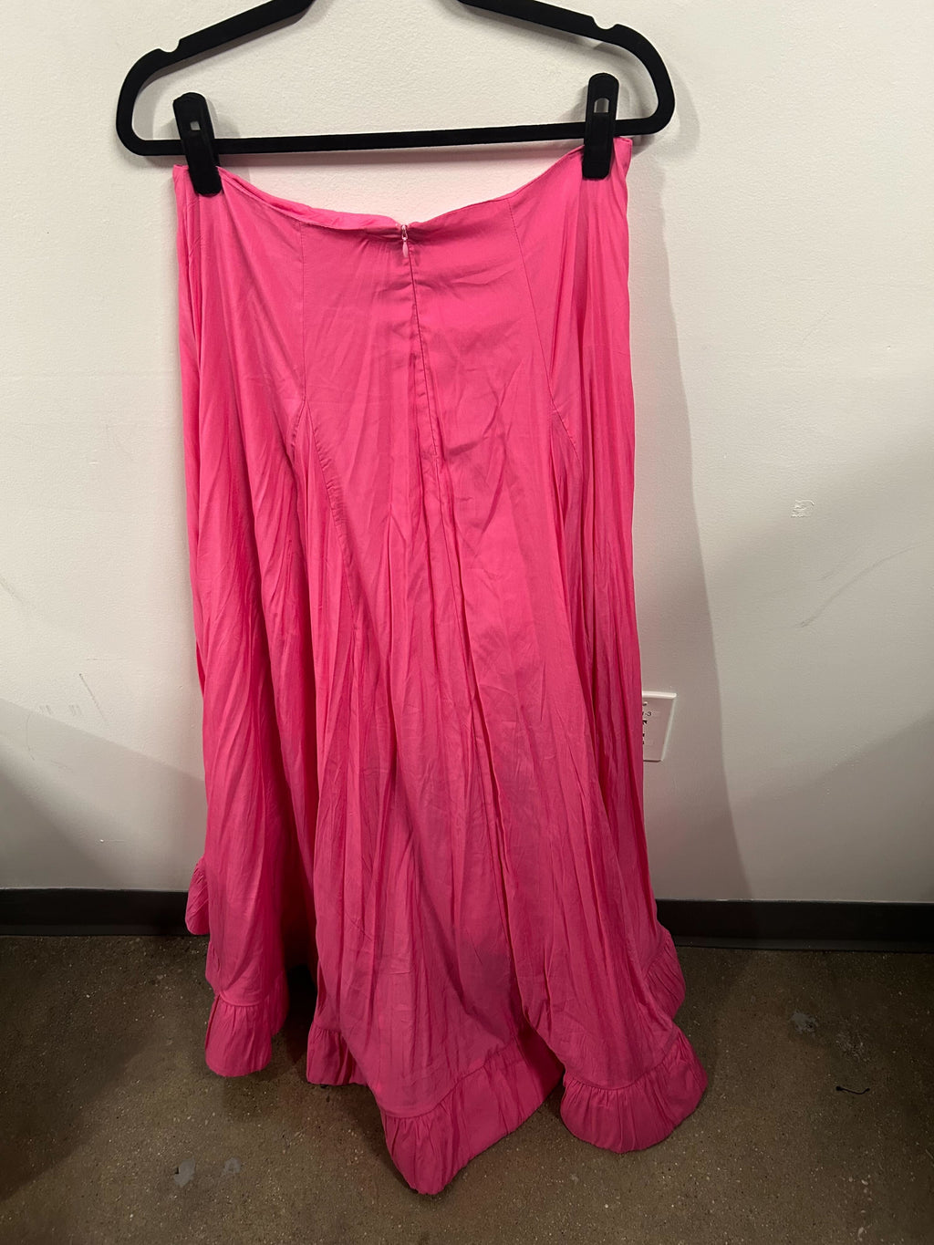 A bright pink sleeveless peplum top with a matching flowy skirt.