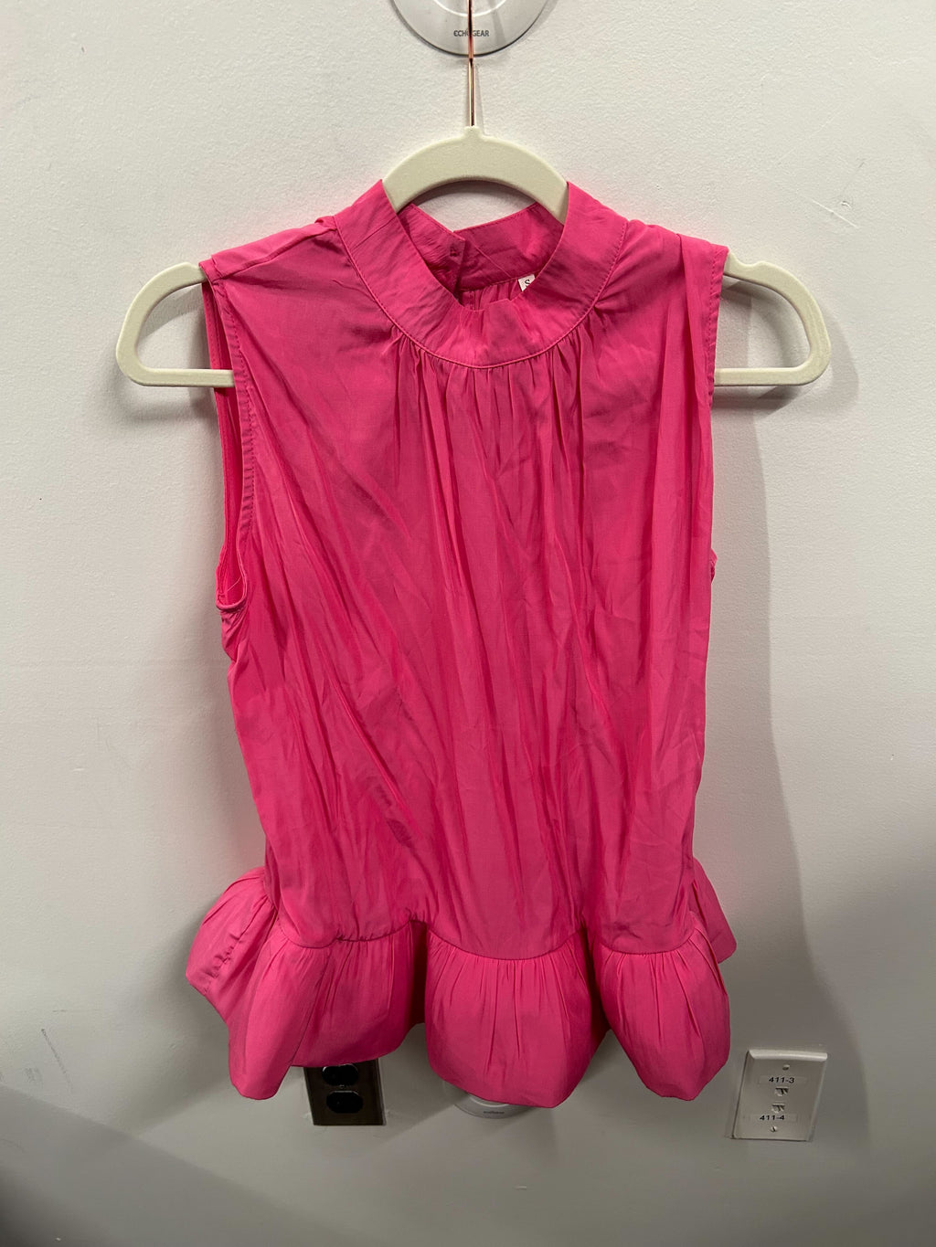 A bright pink sleeveless peplum top with a matching flowy skirt.