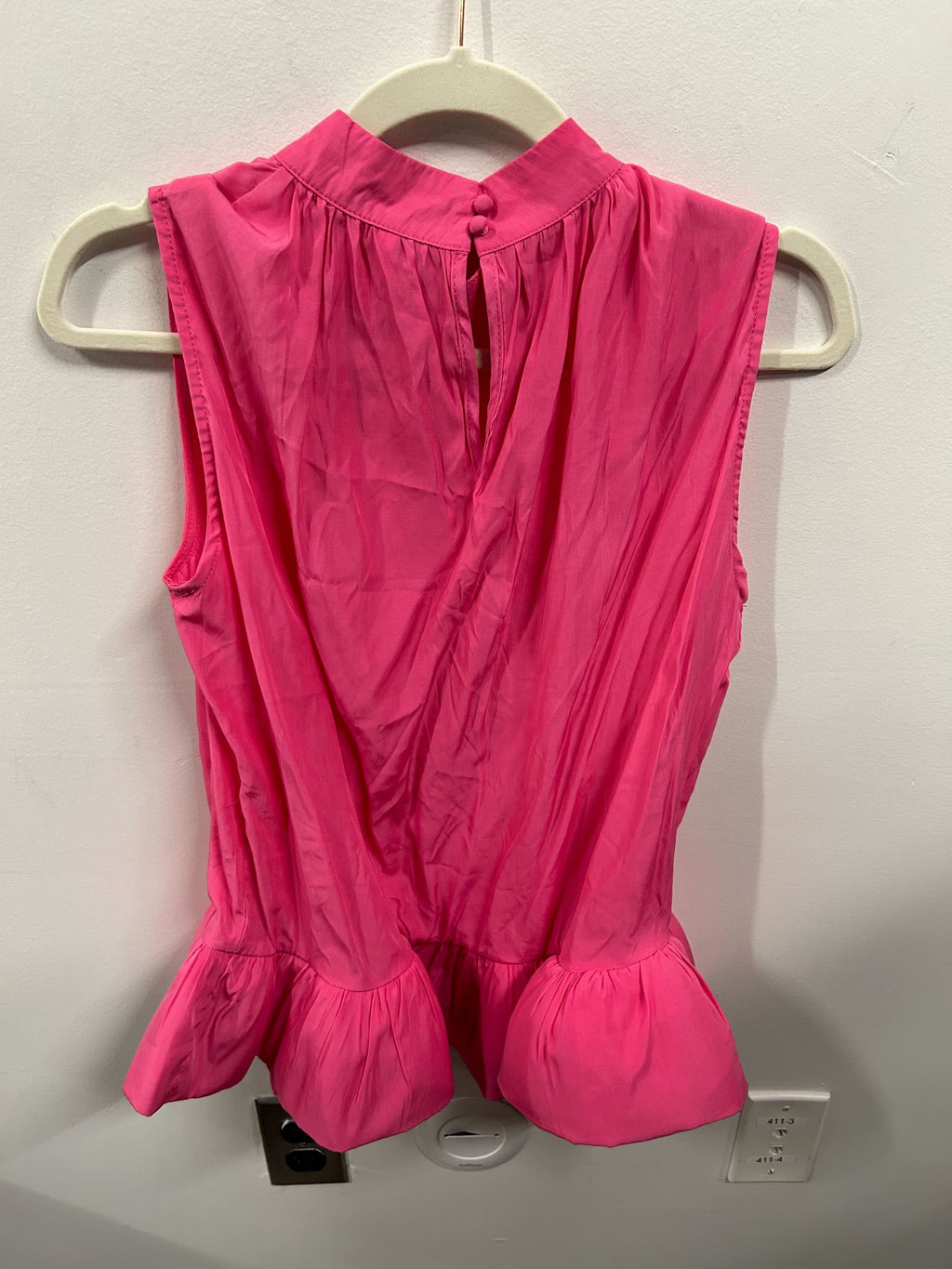 A bright pink sleeveless peplum top with a matching flowy skirt.